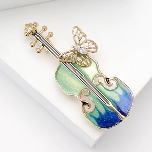 Vue détaillée macro de la broche violon en émail dégradé bleu avec un papillon