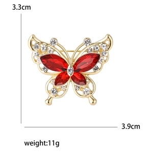 Fashionable butterfly brooch with red rhinestones and white crystals in gold plating