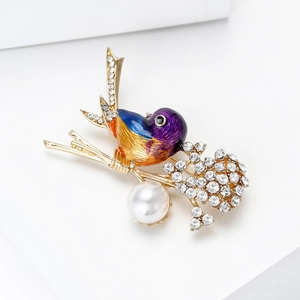 Detail of bird brooch with enamel gradient, crystal accents and white hanging pearl