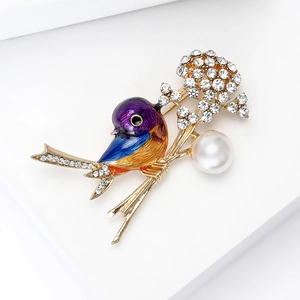 Detailed view of colorful bird brooch with enamel gradient, diamonds, and pearl