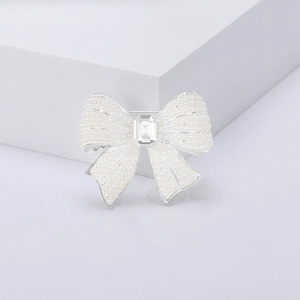 Detailed view of pearl bow brooch with silver base and large center crystal