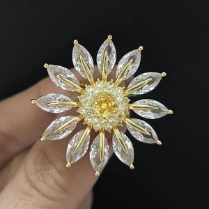 Macro detail of a sunflower ring featuring a yellow center stone and marquise petals