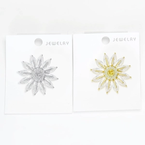 Detailed close-up of daisy brooches with marquise-cut cubic zirconia in gold and silver