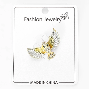 Detail of owl brooch in gold and silver plating with crystal rhinestones on display card