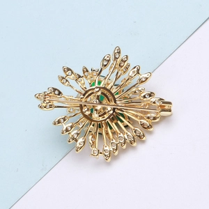 Detailed back view of vintage emerald brooch showing secure safety pin and gold metal finish