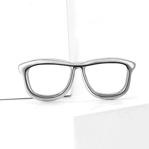 Close-up of minimalist silver eyewear brooch with a polished metallic mirror finish