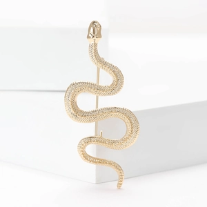 Elegant gold snake brooch with detailed scale texture on minimalist white background