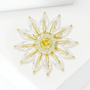 Elegant gold daisy brooch with yellow crystal center and marquise zircon petals