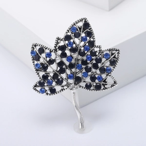 Broche feuille d'érable vintage argentée avec strass bleus et structure évidée