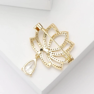 Vue détaillée de l'arrière d'une broche lotus dorée avec fermoir à épingle et zircon