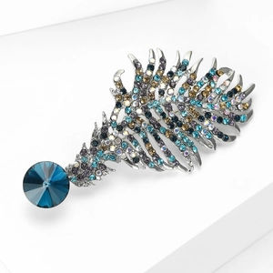 Detail einer silbernen Federbrosche mit bunten Strasssteinen und tiefblauem Hauptstein