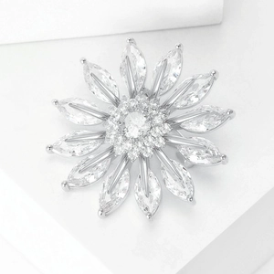 Detailed close-up of a zircon sunflower brooch with silver plating on white blocks