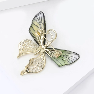 Macro view of the secure rotating safety pin clasp on the golden butterfly brooch back