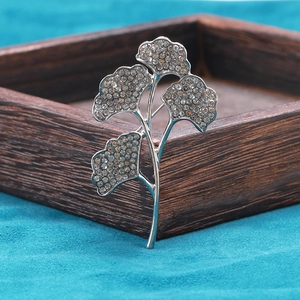 Makroaufnahme der Ginkgoblatt-Brosche mit schimmernden Strasssteinen und Silberfinish
