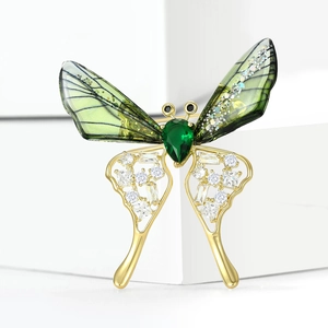 Elegant butterfly brooch with green enamel wings and white zircon inlay in gold finish