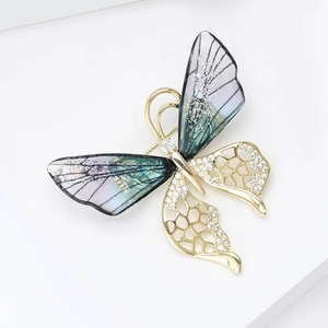 Detail of crystal butterfly brooch with gradient resin wings and rhinestone gold mesh