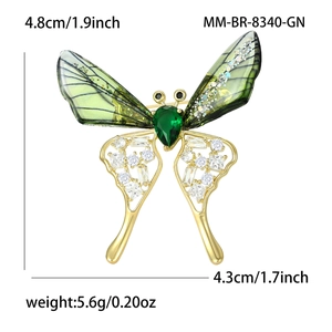 Elegant butterfly brooch with green acrylic wings and sparkling zircons in a gold frame