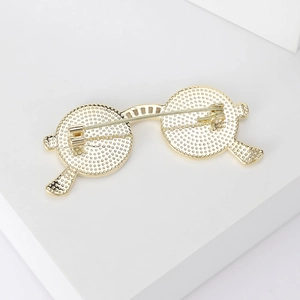 Back view of a creative gold-plated sunglasses brooch with detailed round textures