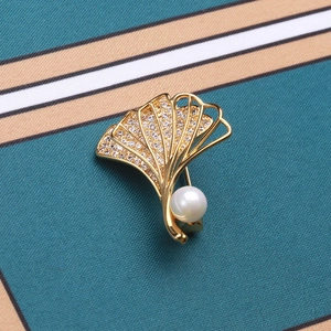 Elegante Ginkgoblatt-Brosche mit Goldbeschichtung, Zirkonia-Inlay und Perle auf Stoff