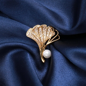Makroaufnahme der Ginkgoblatt-Brosche mit Zirkonia-Pavé und weißem Perlendetail
