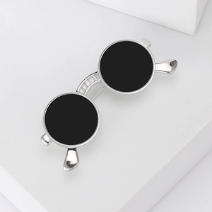 Detail showing the silver sunglasses brooch with sparkling inlaid zircons on a white base