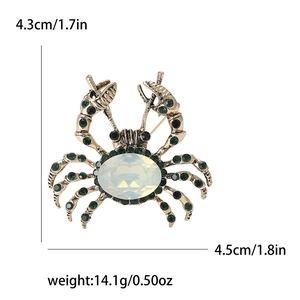 Detailed macro view of crab brooch with white faux gemstone and green rhinestones