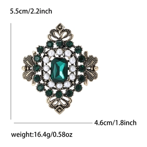 Broche baroque avec cristal vert émeraude, perles et design ajouré doré vintage