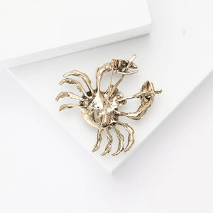 Close-up of gold-plated alloy crab brooch back showing secure safety pin clasp