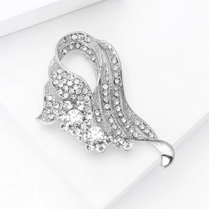 Macro shot of a silver-toned ribbon brooch with sparkling round rhinestones and floral detail