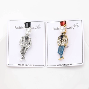 Detailed close-up of rhinestone magician brooches with pearl heads on display cards
