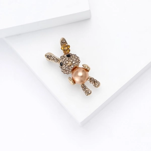 Detalle del broche de conejo dorado con diamantes de imitación y perla central