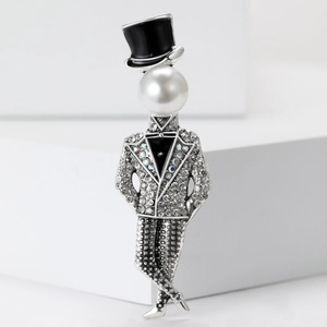 Macro shot of a stylish magician brooch with rhinestones and white pearl on a white block