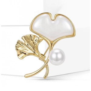 Elegante spilla a foglia di ginkgo dorata con finitura in madreperla e perla bianca