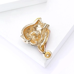 Macro view of the gold alloy brooch back showing the metal pin closure and enamel detail