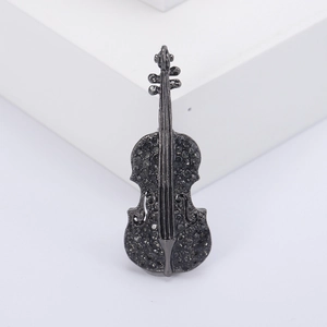 Elegant violin brooch in gun-black alloy with grey rhinestones on a minimalist white stand
