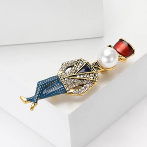 Close-up of fashion magician brooch with white pearls, rhinestones and colorful enamel detail