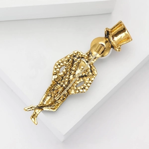 Back view of a gold magician silhouette brooch with a secure metal pin closure on white