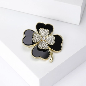 Detail view of a layered clover brooch with black enamel and sparkling rhinestones
