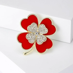 Elegant four-leaf clover brooch with red enamel and white crystals on a gold base