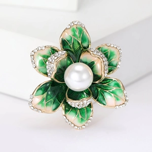Macro shot of elegant enamel flower brooch with pink petals and a white pearl center