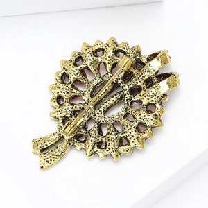Close-up of the vintage gold metal brooch back showing the pin fastener and hollow design