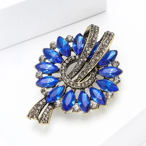 Detailed view of vintage marquise brooch with dark blue crystals and antique gold finish