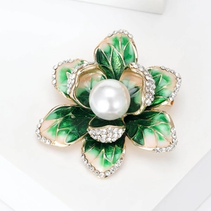 Detail of green enamel begonia brooch with white pearls and sparkling rhinestones