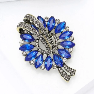 Detailed close-up of retro sunflower brooch with sapphire blue marquise stones and rhinestones