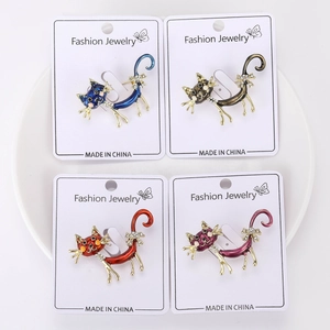 Detailed view of four colorful enamel cat brooches with rhinestones on a white display card