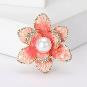 Detailed macro view of pink enamel flower brooch with large white pearl and zircon accents