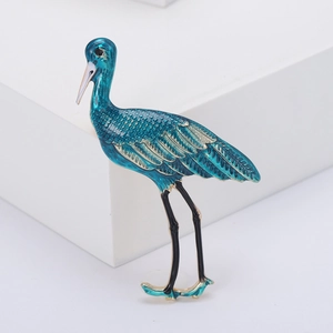 Élégante broche oiseau grue en émail bleu paon avec des bords de plumes dorés