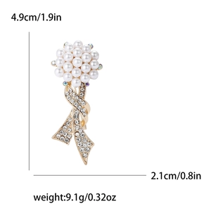 Elegant gold bouquet brooch with white pearls and sparkling rhinestones on white background