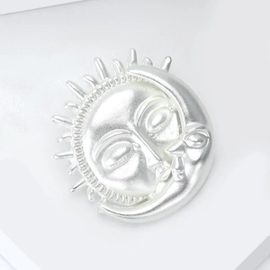 Détails de la broche soleil et lune en argent mat avec des textures de visage fines
