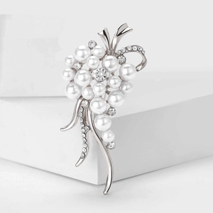 Détails de la broche en forme de grappe avec perles blanches et strass sur socle moderne